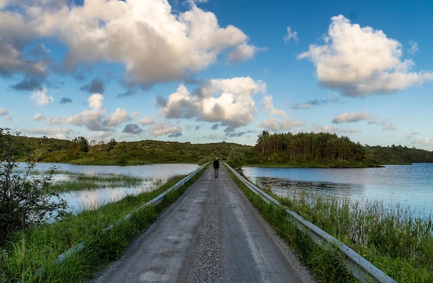 Man staat op de weg te midden van het landschap tegen de lucht