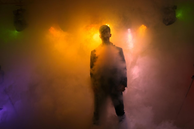 Man staat te midden van verlichte rook op het podium