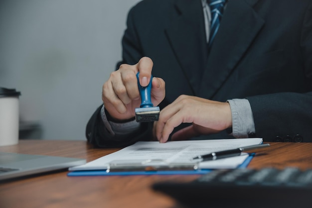 Man stamping approval of work finance banking or investment marketing documents on desk