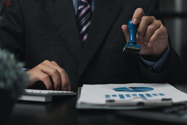 Man stamping approval of work finance banking or investment marketing documents on desk