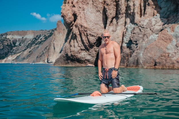 Uomo su uno stand up paddleboard sul mare