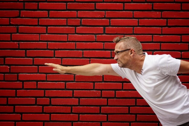 Photo man standing against brick wall