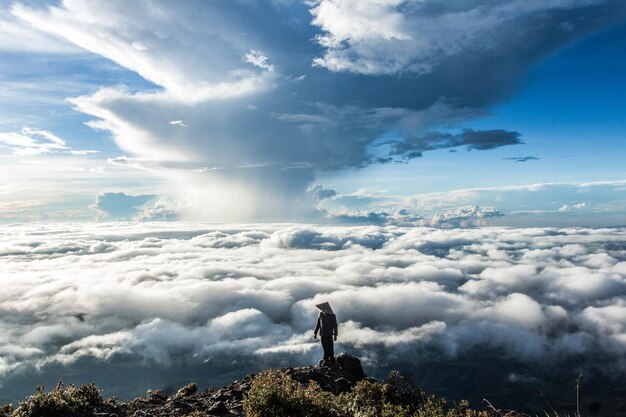 Foto l'uomo in piedi contro il paesaggio nuvoloso