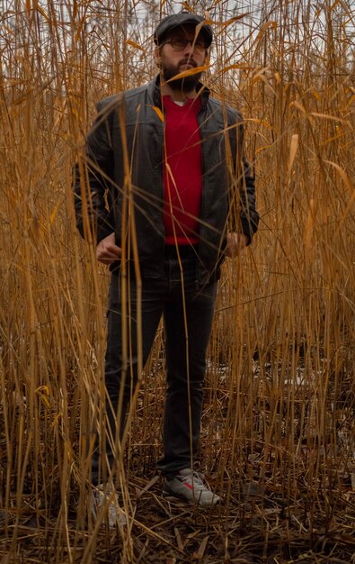 Man standing amidst plants on field