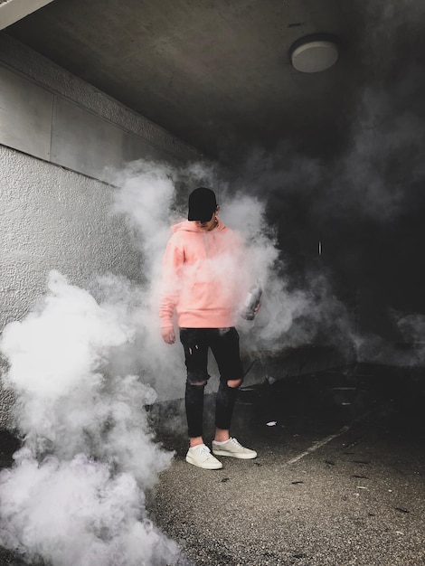 Man standing amidst smoke on road