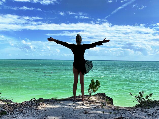 Photo man standing at beach against sky