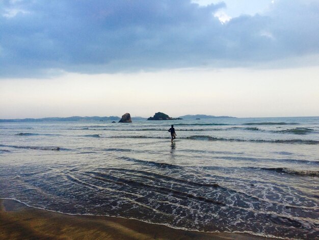 Photo man standing on beach against sky