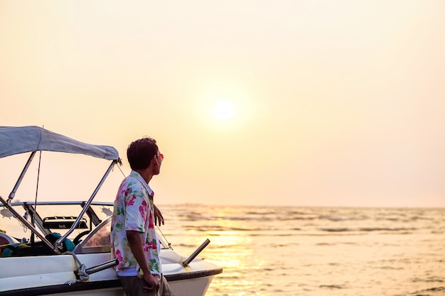 man standing on the beach and watching the sunset.