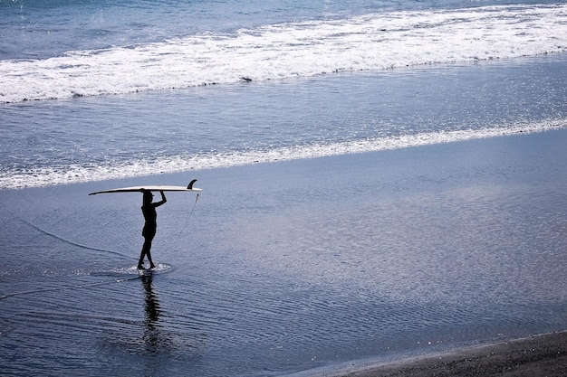 Foto uomo in piedi sulla spiaggia