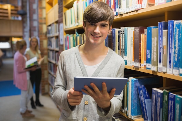 Man standing at a bookshelf with tablet pc