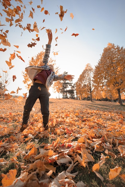 Photo man standing by dry leaves during autumn