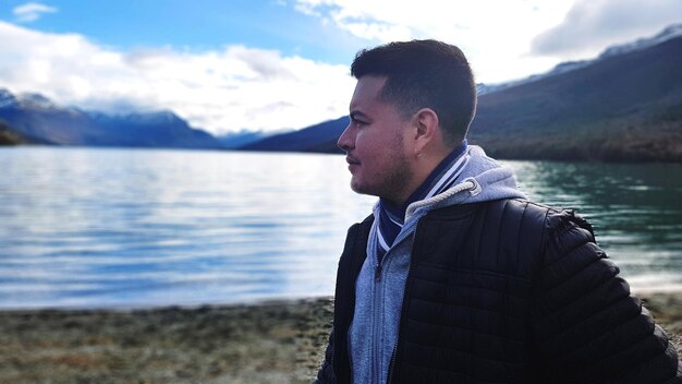 Photo man standing by lake against sky