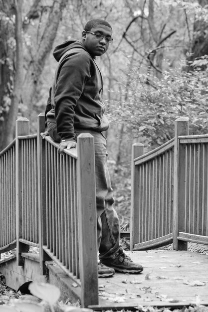 Photo man standing by railing on walkway at park