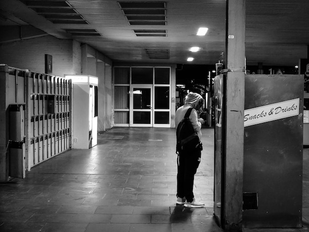 写真 鉄道駅のスナック自販機のそばに立っている男