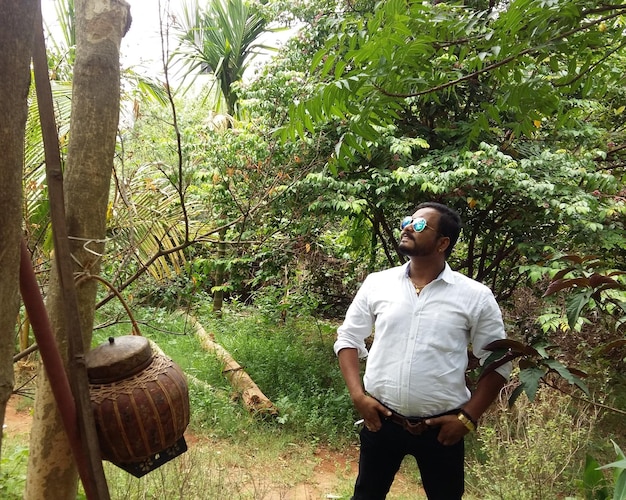 Man standing by tree in forest