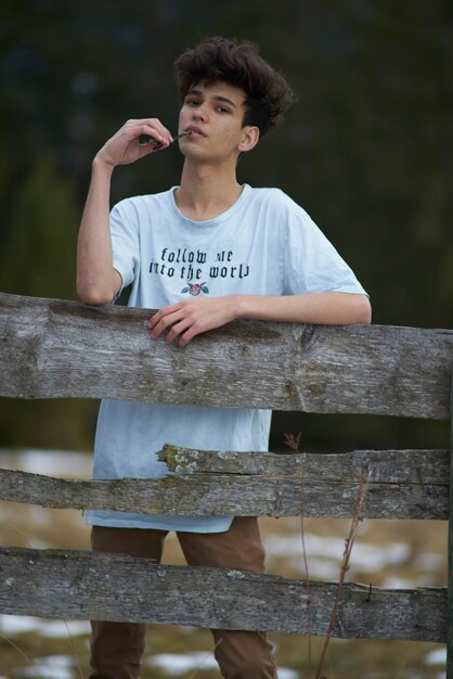 Photo man standing by wooden railing