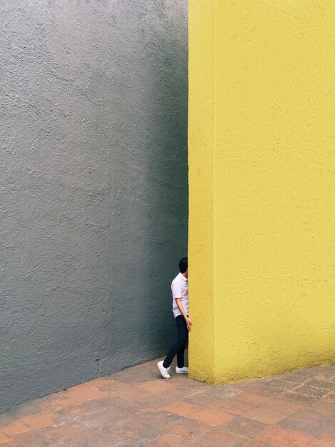 Photo man standing by yellow wall