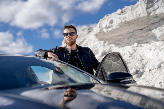 A man standing next to a car in the snow