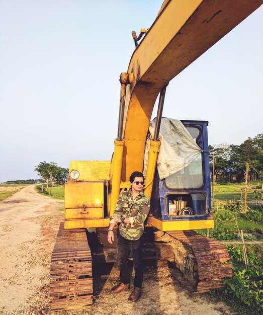 Foto uomo in piedi sul cantiere di costruzione contro il movimento della terra