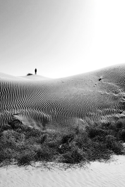 Photo man standing on desert against sky