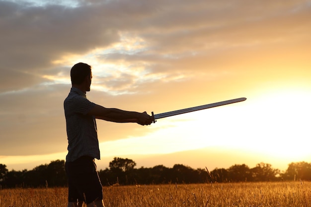 Man standing on field against sky during sunset