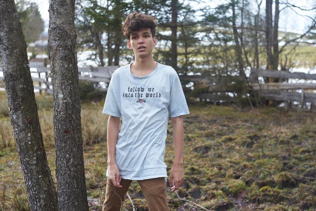 Foto uomo in piedi sul campo nella foresta