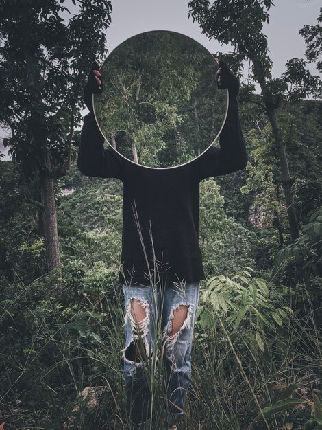 Man standing on field in forest