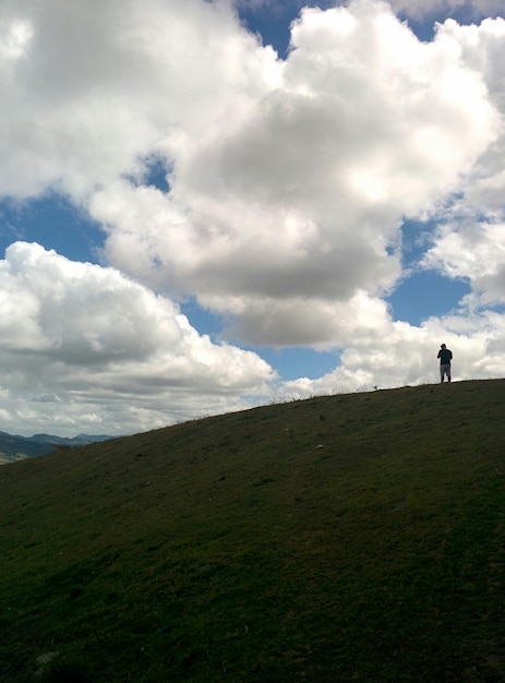 Foto uomo in piedi sulla collina