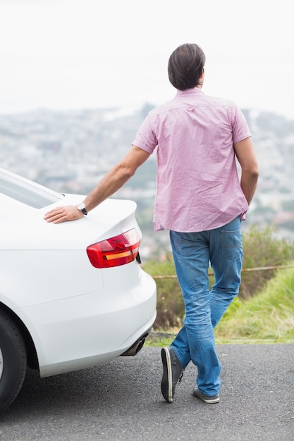 Foto uomo in piedi accanto alla sua auto