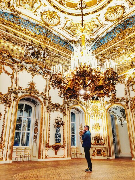 Foto uomo in piedi sotto un lampadario illuminato al burgtheater