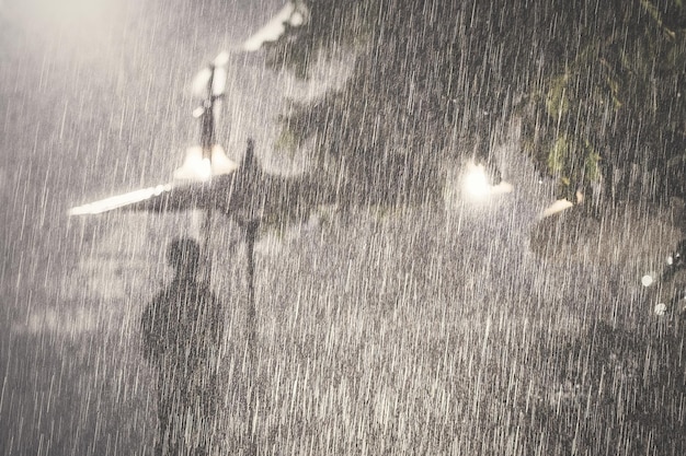 Фото Человек, стоящий под дождем в очень дождливый день