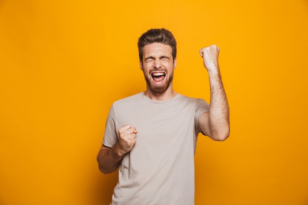 Man standing isolated make a winner gesture.