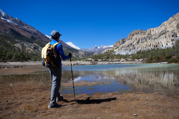 Equipaggi la condizione per guardare la vista del lago con le montagne della neve