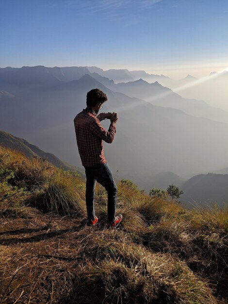 Man standing on mountain against sky