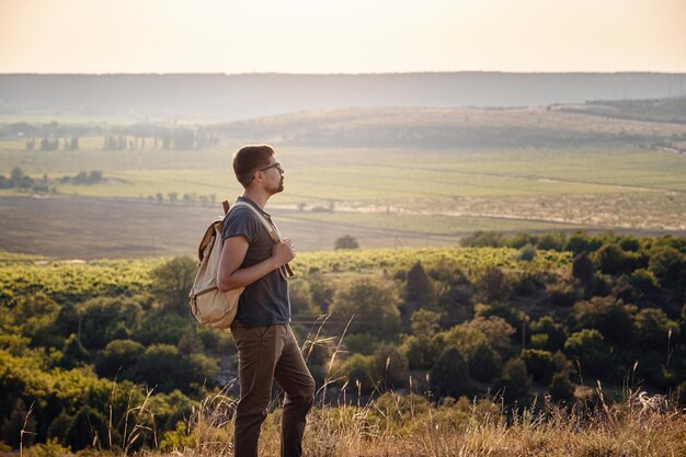 A man standing on a mountain as the sun sets