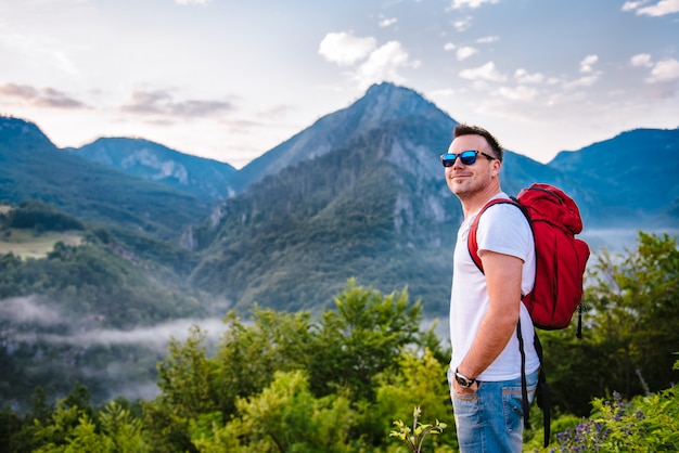 Foto uomo in piedi sulla montagna e sorridente