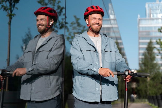 写真 彼のスクーターの隣に立っている男