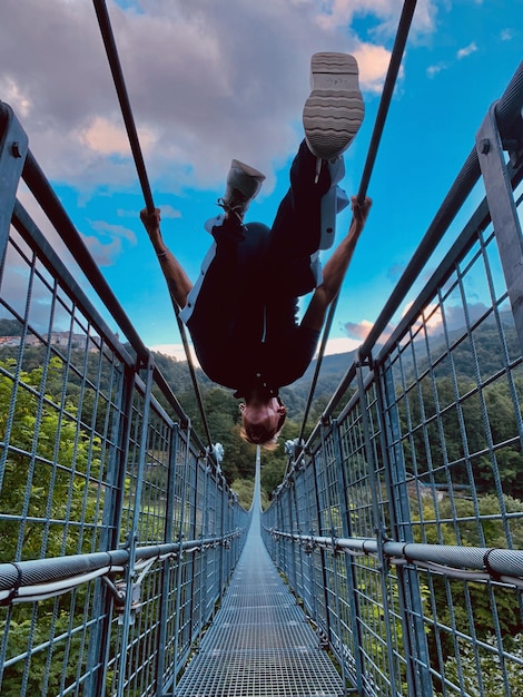 写真 空に向かって歩道橋の上に立っている男