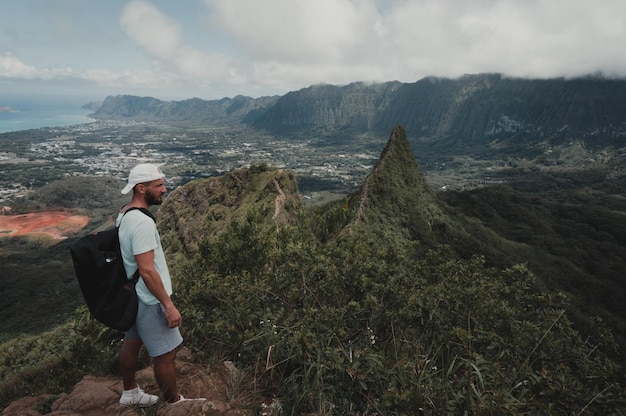 写真 天に向かって山の上に立っている男