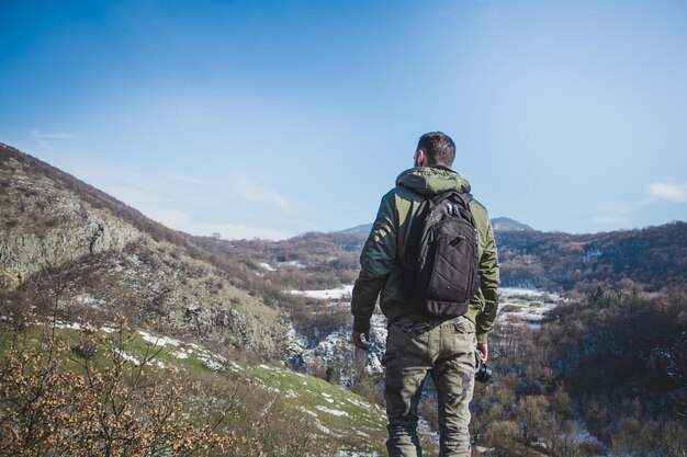 写真 天に向かって山の上に立っている男