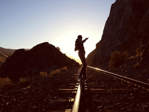 写真 空に向かって鉄道線路に立っている男