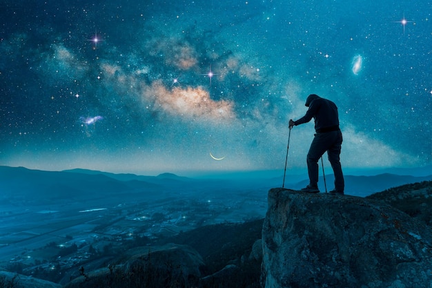 야외에서 산 정상에 서 있는 남자는 은하수와 별 아래의 뒷모습 x9