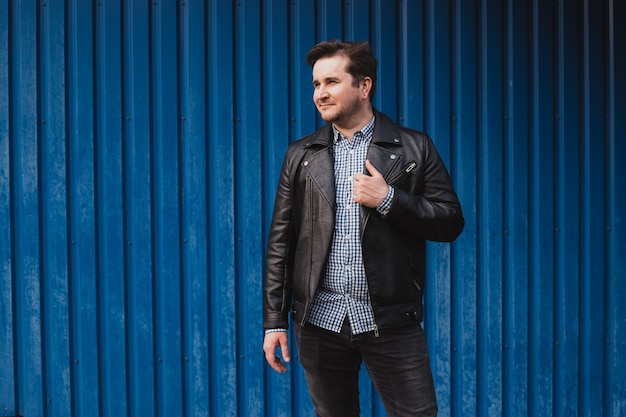 Man standing outside a blue wall, copyspace, place for text