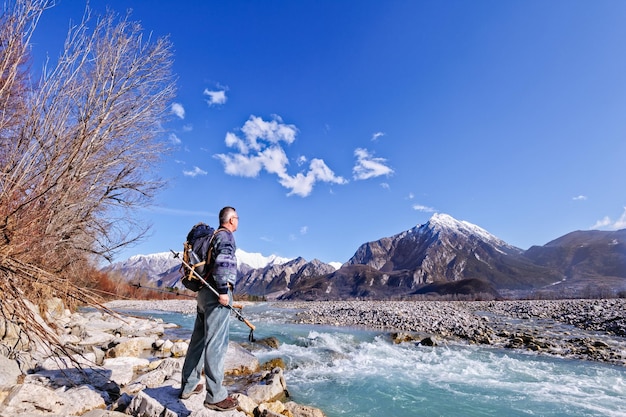 Man standing on river against blue sky