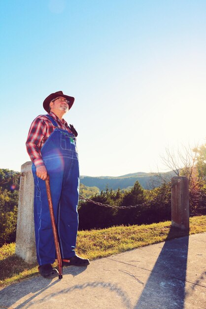 Man standing on road against clear sky during sunny day