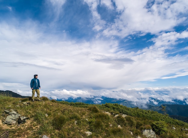 L'uomo in piedi sulla roccia contro belle nuvole