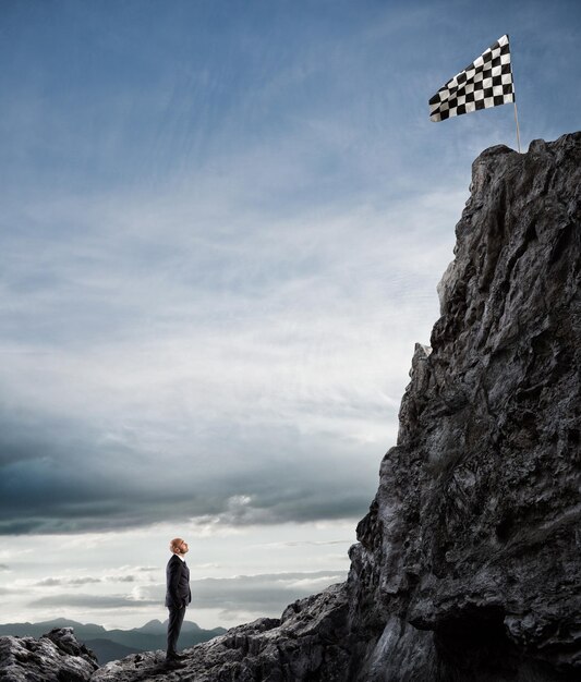 Foto uomo in piedi sulla roccia dalla montagna contro il cielo