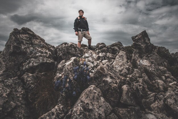 Photo man standing on rock formation against sky