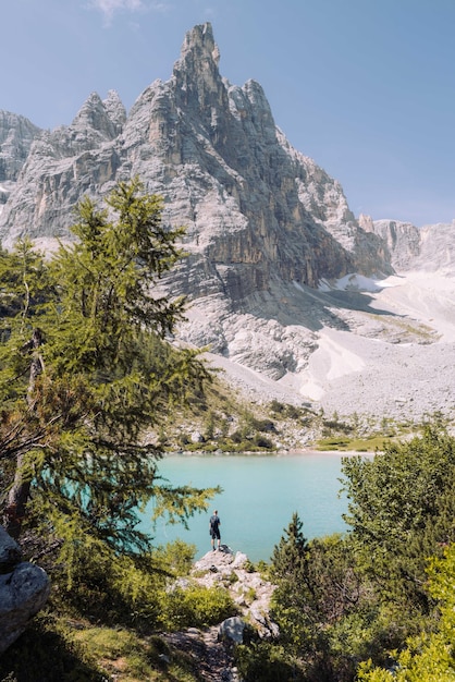 Photo man standing on the rock overlooking lake sorapis