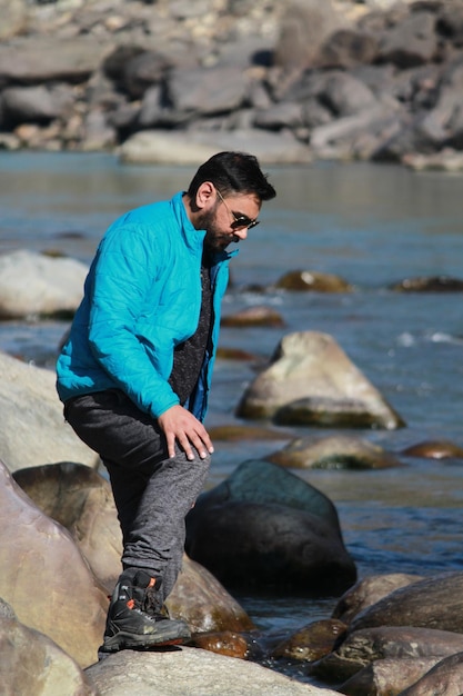 Man standing on rock at river